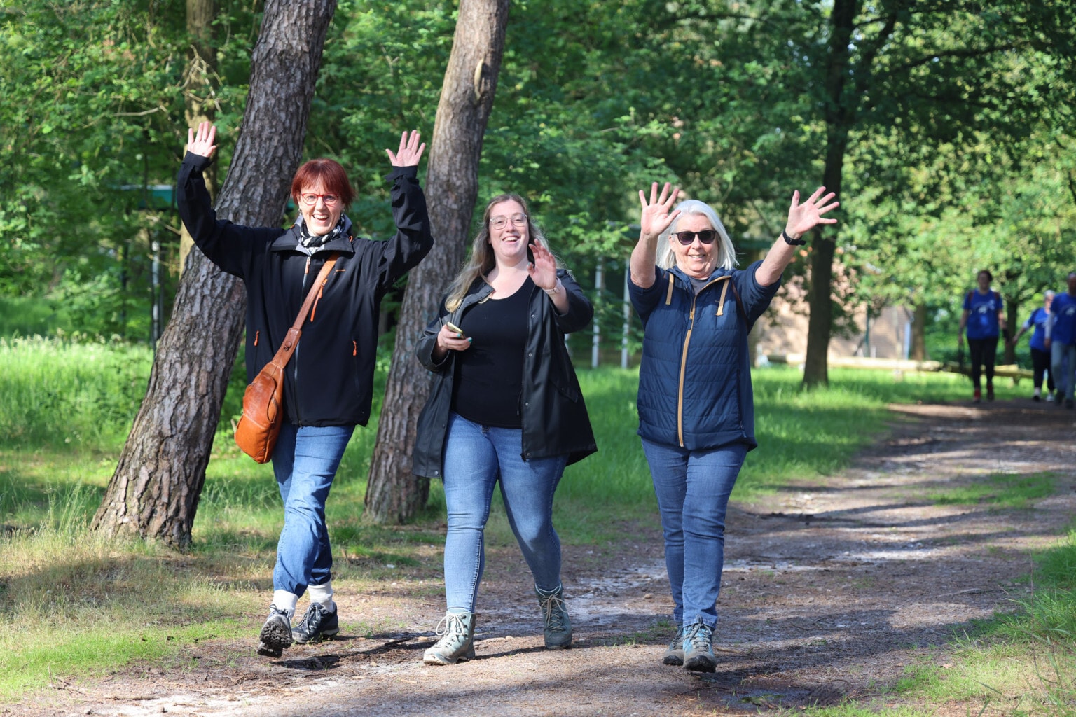 Drie blije wandelen vrouwen in het bos.
